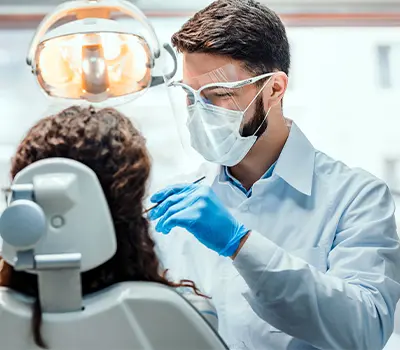 Dentist examining patient's teeth in treatment room