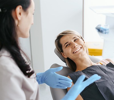 Female patient in the treatment chair smiling at her dentist
