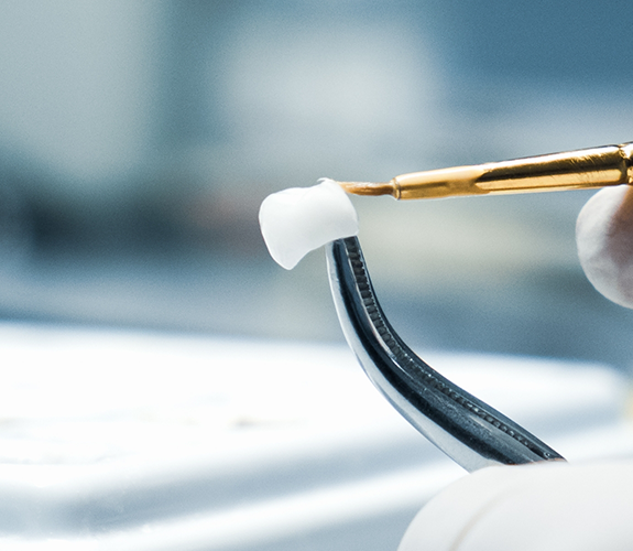 Close up of fine dental instruments holding a veneer