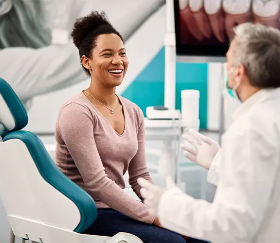 Smiling patient talking to dentist in treatment room