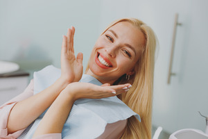 Blonde woman in dental chair showing off smile