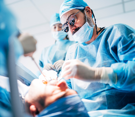 Dentist and assistants performing dental implant surgery on a patient