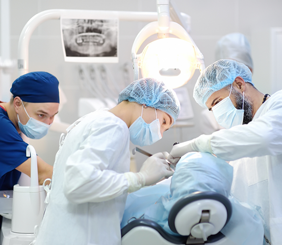 Dental team performing tooth extractions on a patient